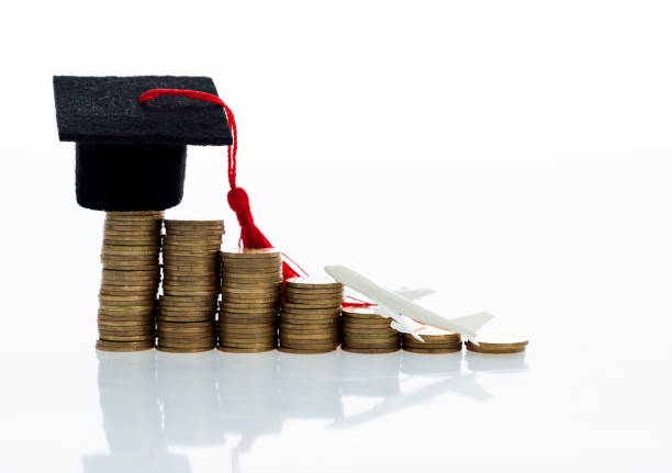 istock Graduation hat and plane toy on coins 880924824