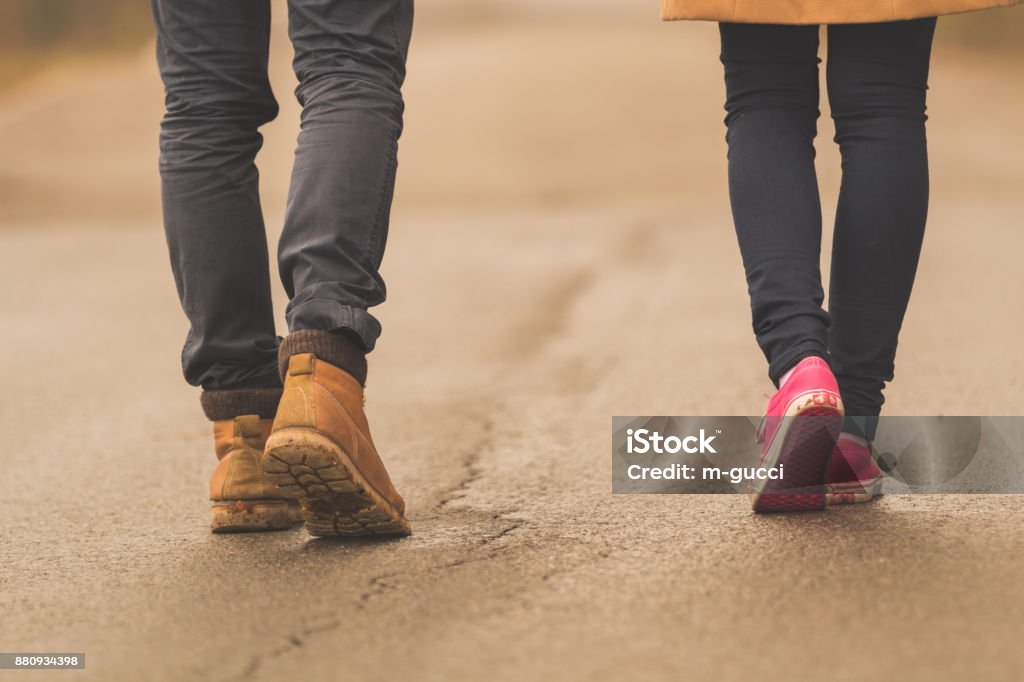 Young couple / pair walking down the street. Foot Stock Photo