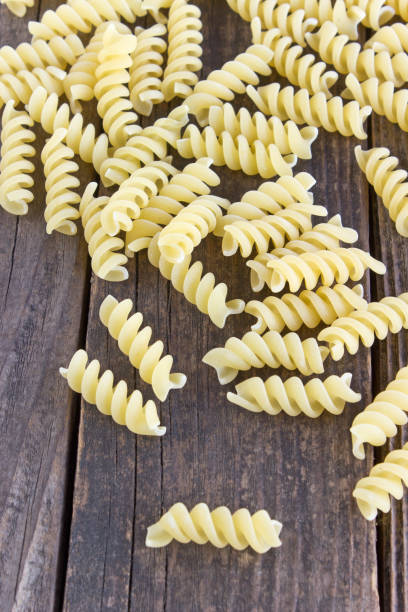 istock Fusilli pasta on wooden background 880939696