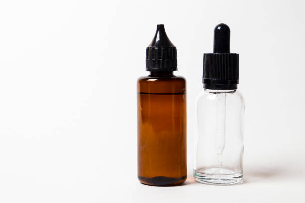 istock e- liquid, e-juice in the bottles isolated on the white background with copyspace 880947550