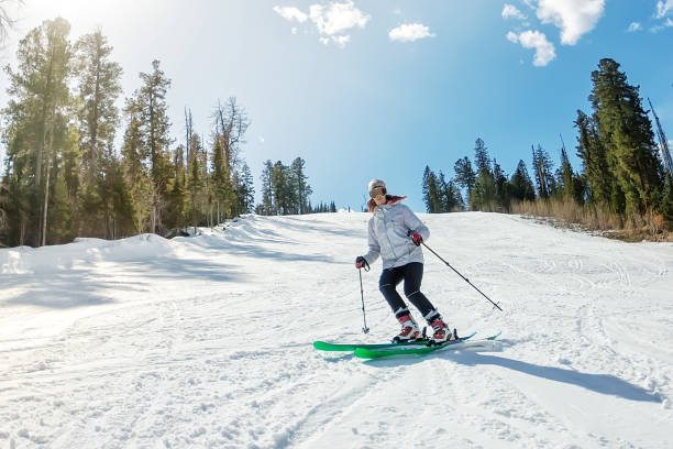 ragazza sullo sci alpino su una pista innevata contro il cielo - skiing snow mountain canada foto e immagini stock