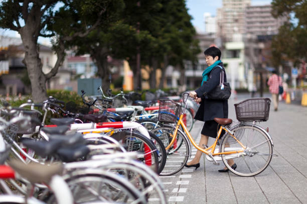 A Japanese businesswoman is parking her bicycle.