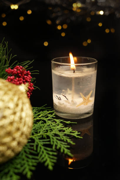 istock Christmas candlelight with fir and decor on glitter background 880959760