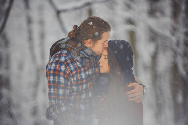 istock Happy loving couple walking in snowy forest 880966152