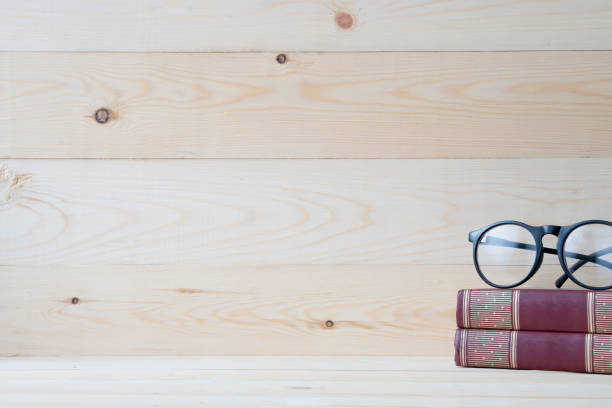 istock Eyeglasses and book on Wood table 880973270