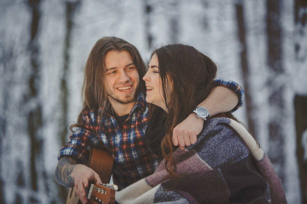 istock Man plays guitar to his girlfriend in winter forest 880973524