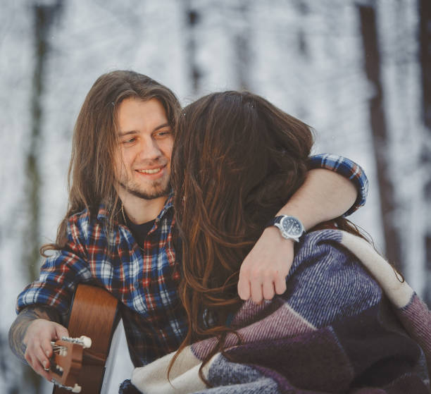 istock Man plays guitar to his girlfriend in winter forest 880973576