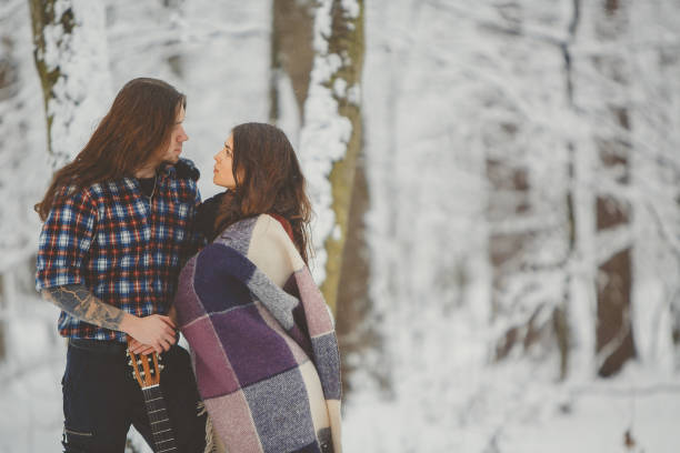 istock Happy loving couple in snowy winter forest 880976002