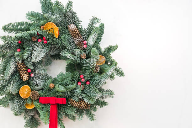istock festivities, greeting, decor concept. marvelous christmas wreath made of conifer tree and embelished with dried slices of lemon and orange, pinecones and bright red tidy bow, with free space for text 880976574