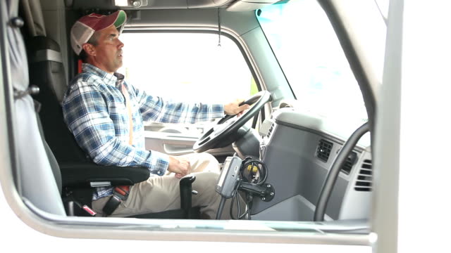 Mature man climbing into cab of semi-truck