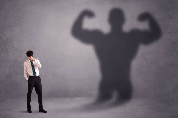 istock Business man looking at his own strong fit shadow concept 881011504