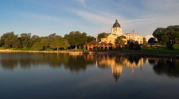 Water reflects the American Flag waving in front of the capitol dome in Pierre, SD