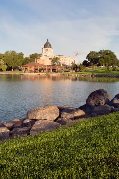 Water reflects the American Flag waving in front of the capitol dome in Pierre, SD