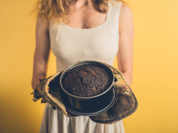 istock Young woman holding a burnt cake 881064474