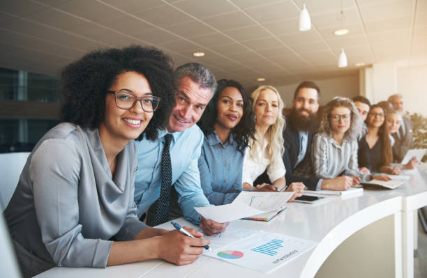 istock Smiling group of diverse colleagues working together in an office 881068322