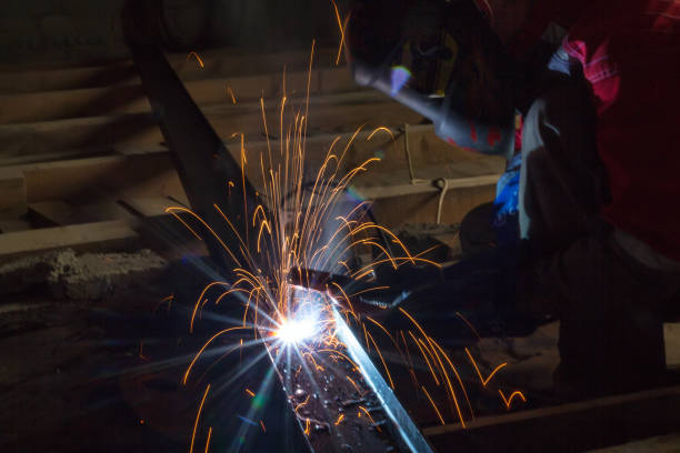 istock Welder in a protective suit and mask at work 881068396