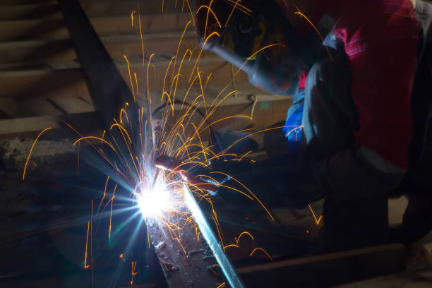 istock Welder in a protective suit and mask at work 881068426