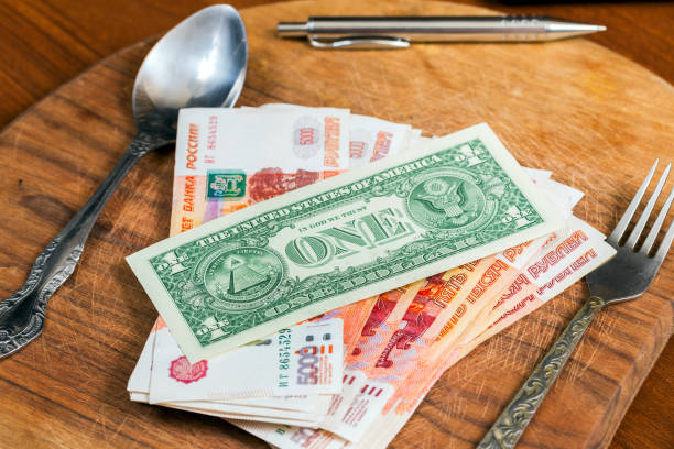 istock US dollar and Russian ruble on a kitchen cutting board 881068434
