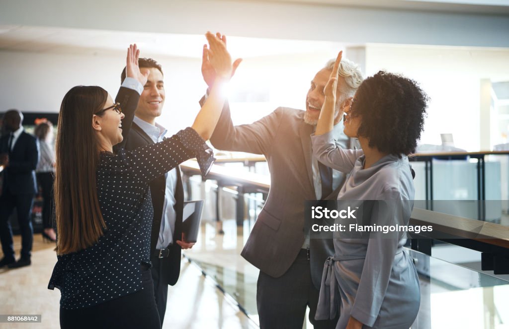 Souriant haute fiving d’affaires collègues mutuellement dans un bureau - Photo de Affaires libre de droits