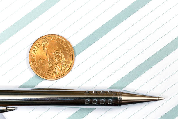 istock Notebook or diary with a pen and a dollar coin 881068490