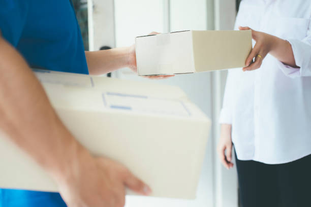 istock Young woman receiving parcel from delivery man. 881072706