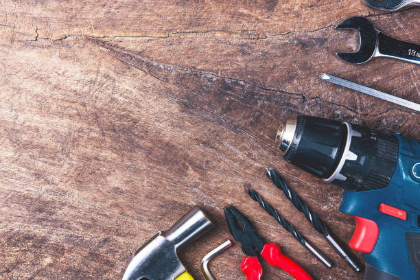 istock Top view of Working tools,wrench,socket wrench,hammer,screwdriver,plier,electric drill,tape measure,machinist square and safety glasses on wooden background.flat lay design. 881073052