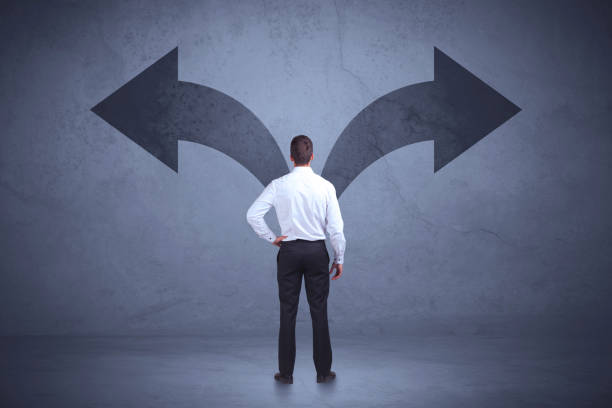 istock Businessman taking a decision while looking at arrows on the wall concept 881073216