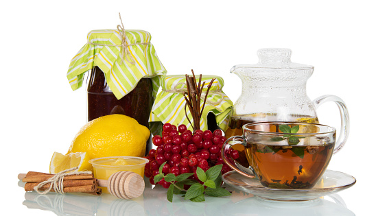 Jam hot tea with honey and lemon, viburnum berries and cinnamon, isolated on white background