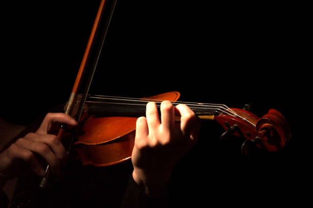 istock Hands of woman playing violin isolated on black 881084806
