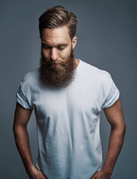 istock Bearded young man standing alone against a gray background 881092790