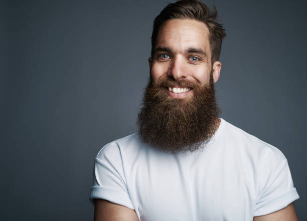 istock Bearded young man smiling against a gray background 881094916