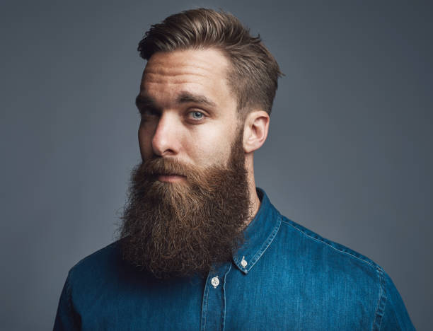 istock Bearded young hipster standing alone against a gray background 881095082