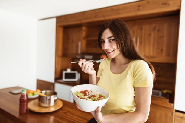 istock woman eating a vegetable 881095422