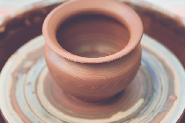 istock Potter making ceramic pot on the pottery wheel 881102828
