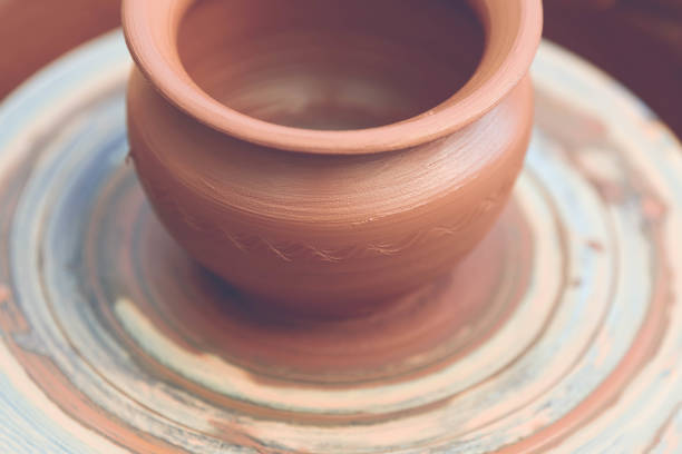 istock Potter making ceramic pot on the pottery wheel 881102856