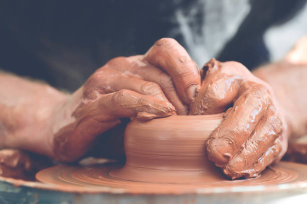 istock Potter making ceramic pot on the pottery wheel 881102872