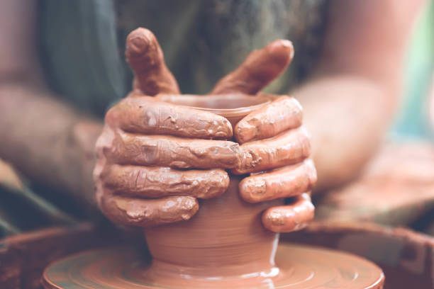 istock Potter making ceramic pot on the pottery wheel 881102944