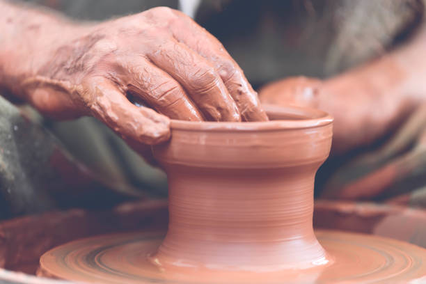 istock Potter making ceramic pot on the pottery wheel 881102948