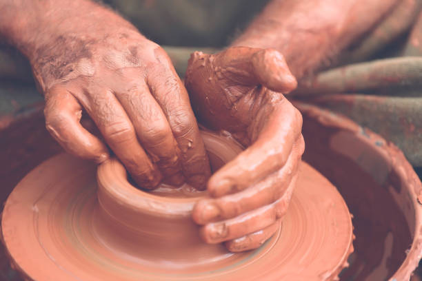 istock Potter making ceramic pot on the pottery wheel 881102986