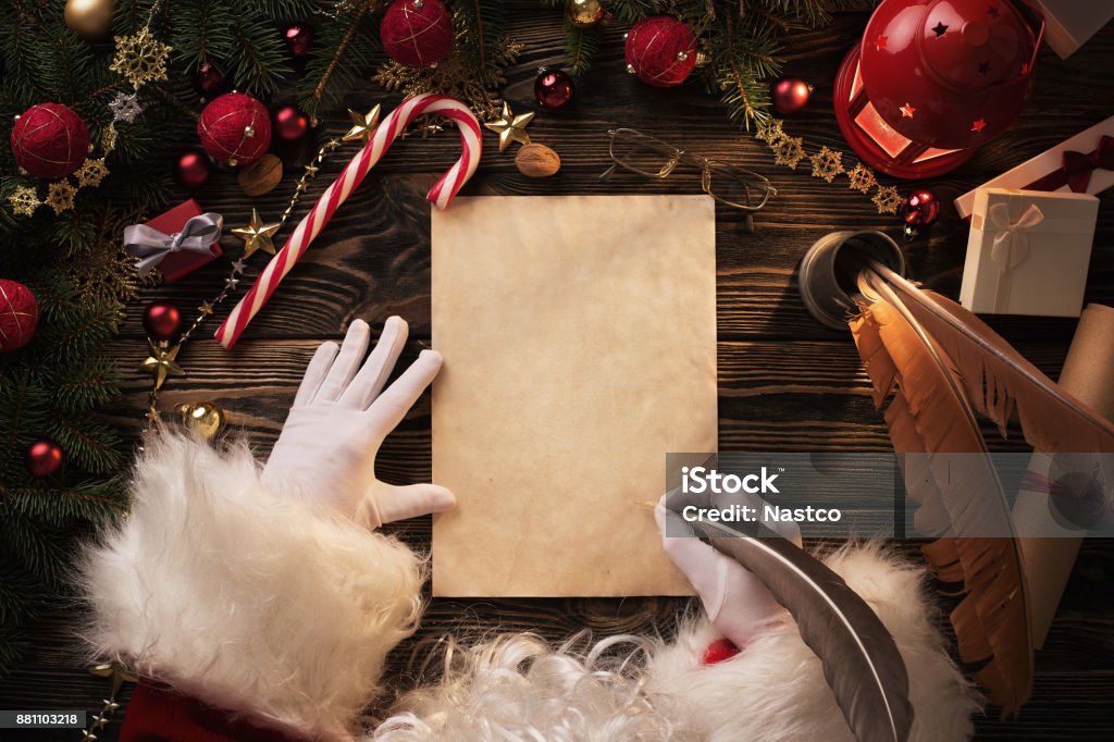 Santa Claus writting letter on wooden table Christmas background, Santa Claus writting on blank paper sheet over wooden table with copy space Santa Claus Stock Photo