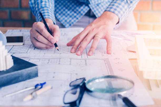istock Concept architects,engineer holding pen pointing equipment architects On the desk with a blueprint in the office, Vintage, Sunset light.Selective Focus 881108172