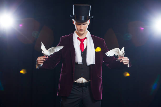 istock The magician with a two flying white Doves. on a black background 881108554