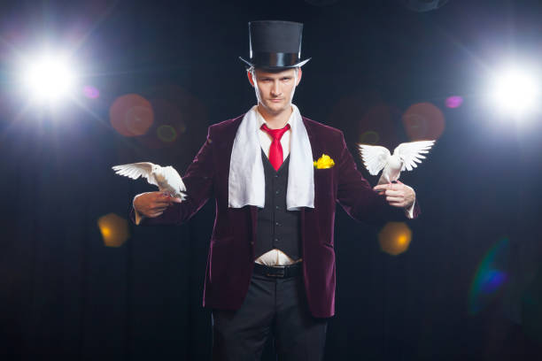 istock The magician with a two flying white Doves. on a black background 881108624