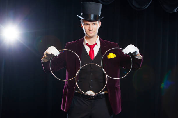 istock magic, performance, circus, show concept - magician in top hat showing trick with linking rings 881111150