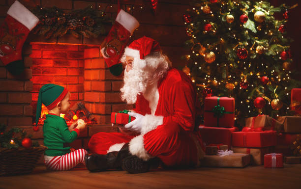 istock Santa Claus and little elf with magic gift for Christmas 881111236