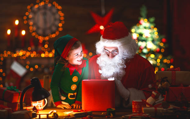 Santa Claus and little elf with magic gift for Christmas Santa Claus and little elf with a magic gift for Christmas santa claus elf assistance christmas stock pictures, royalty-free photos & images