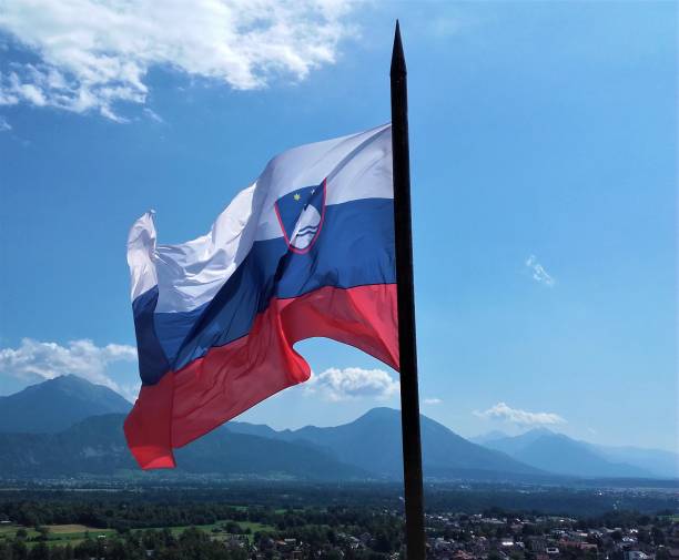 istock Slovenian flag over lake Bled in front of mountains 881111598