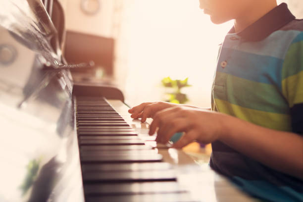 istock Closeup of a little boy playing piano 881114004