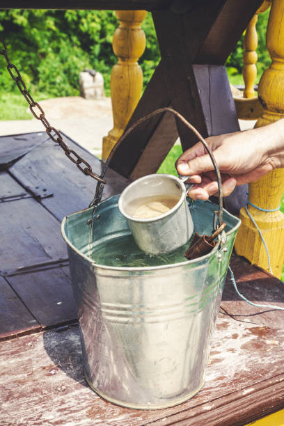 istock Hand picking up water from bucket iron mug 881121676
