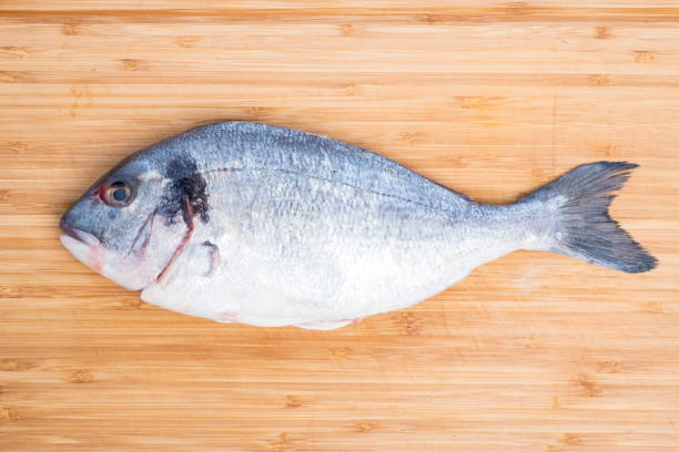 istock Raw Sea Bream on a Bamboo Cutting Board 881121686